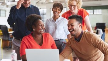 Laughing HR team working together on a laptop