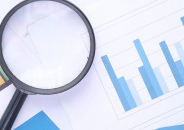 A magnifying glass over a data chart