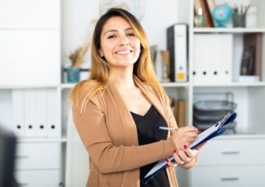 Young woman manager thinking and holding a clipboard