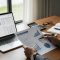 Business professional reviewing financial forecasting charts and graphs on a laptop and printed reports.